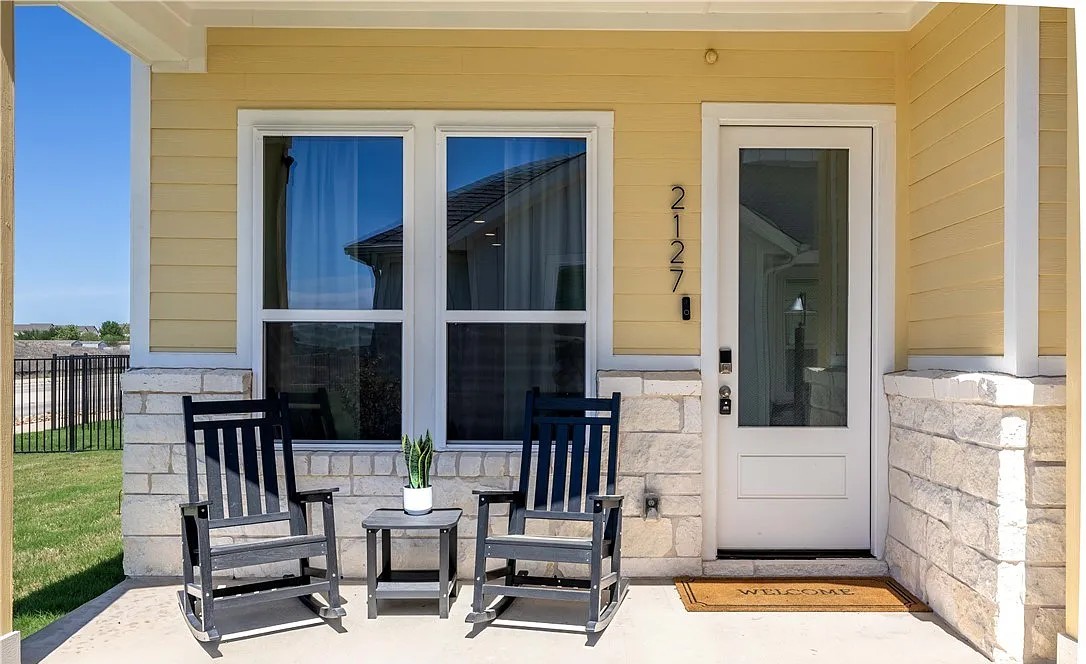 Covered cottage porch with rocking chairs and limestone base